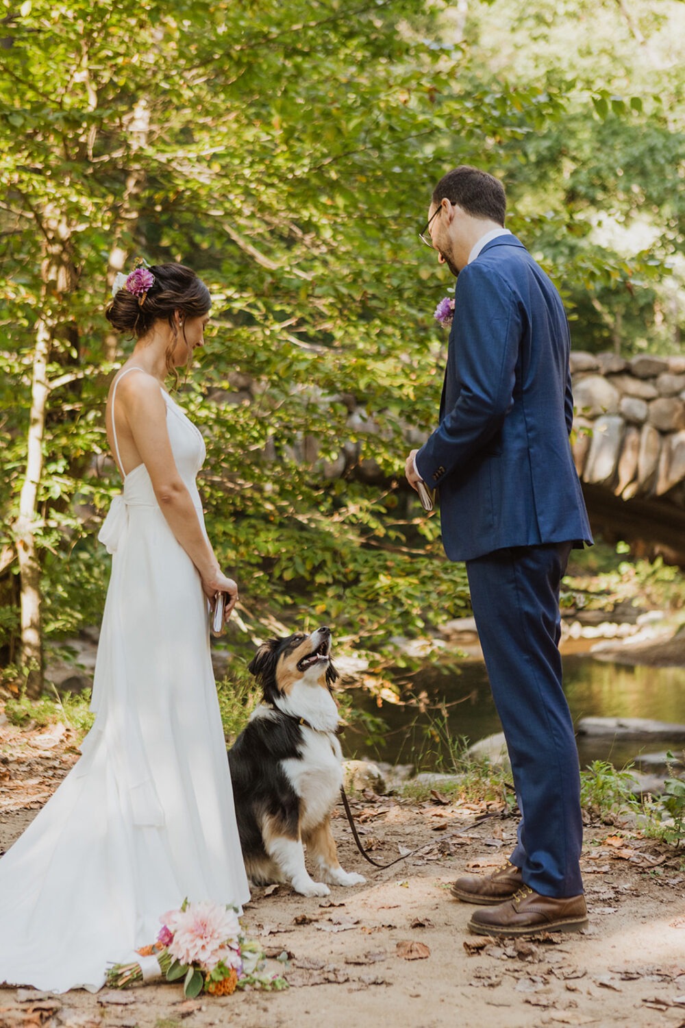 couple poses with their dog on their wedding day