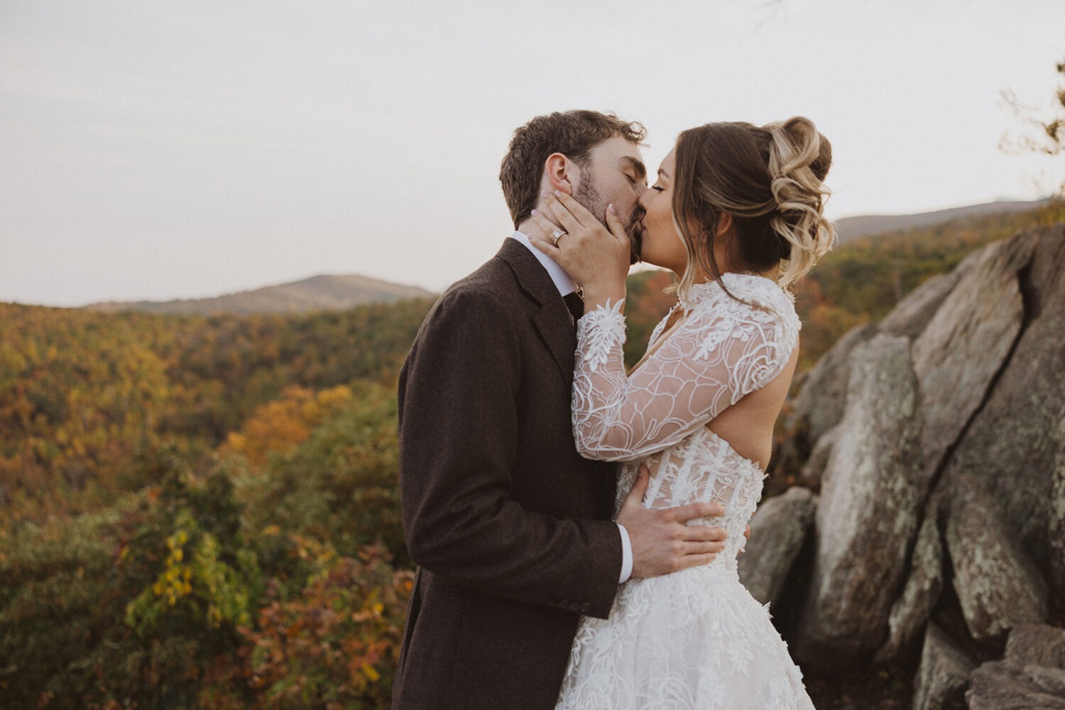 couple kisses in front of mountains in Shenandoah National Park
