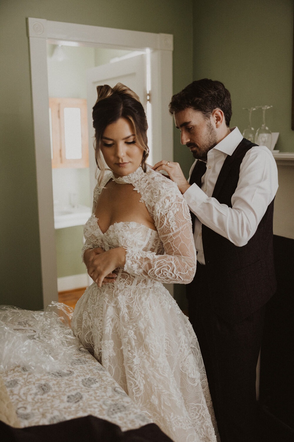 groom helping bride with dress for pre-wedding photos