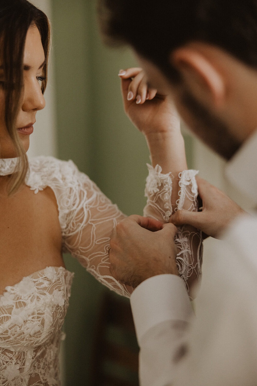groom helping bride with dress for pre-wedding photos