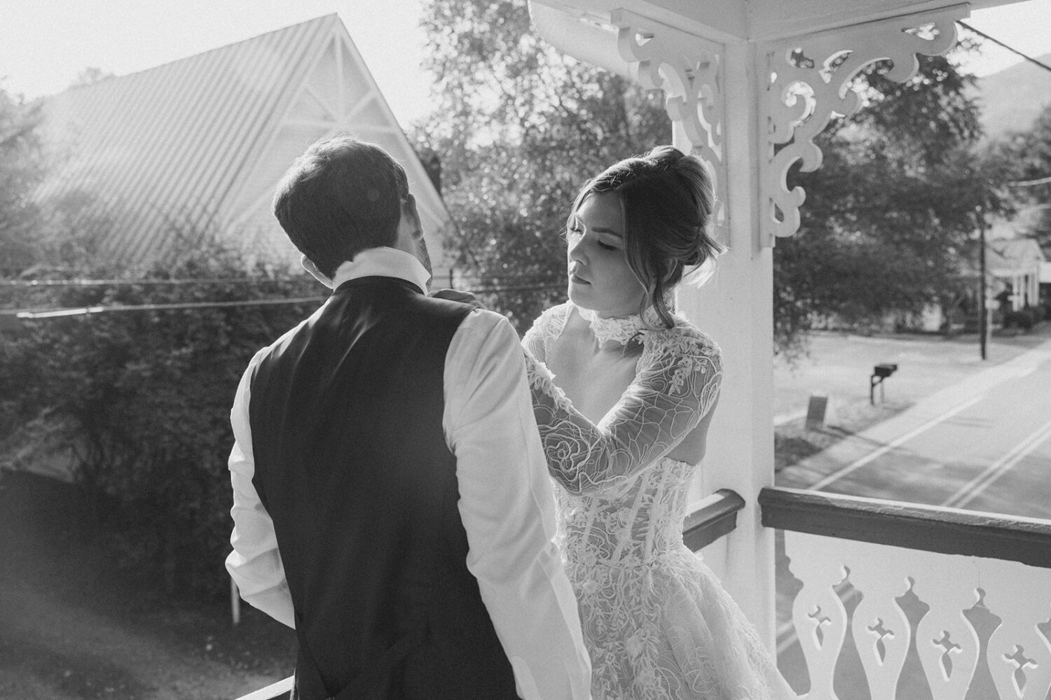 bride helping groom with tie before pre-wedding photos