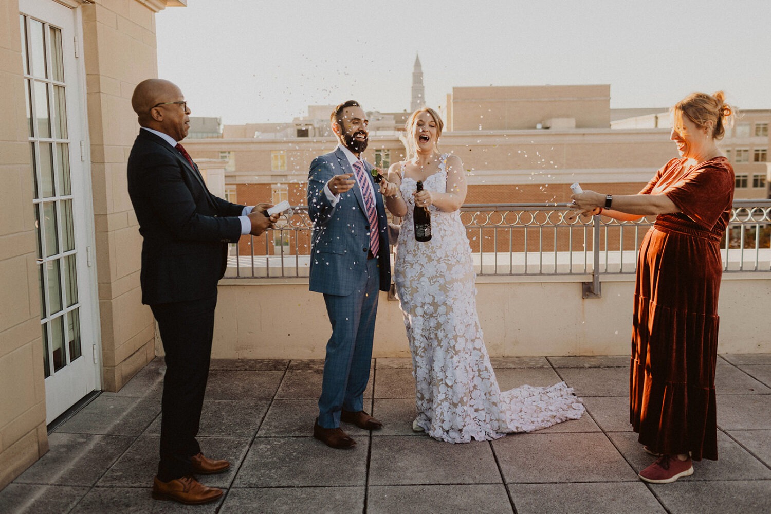 small wedding party celebrate with bride and groom by popping champagne