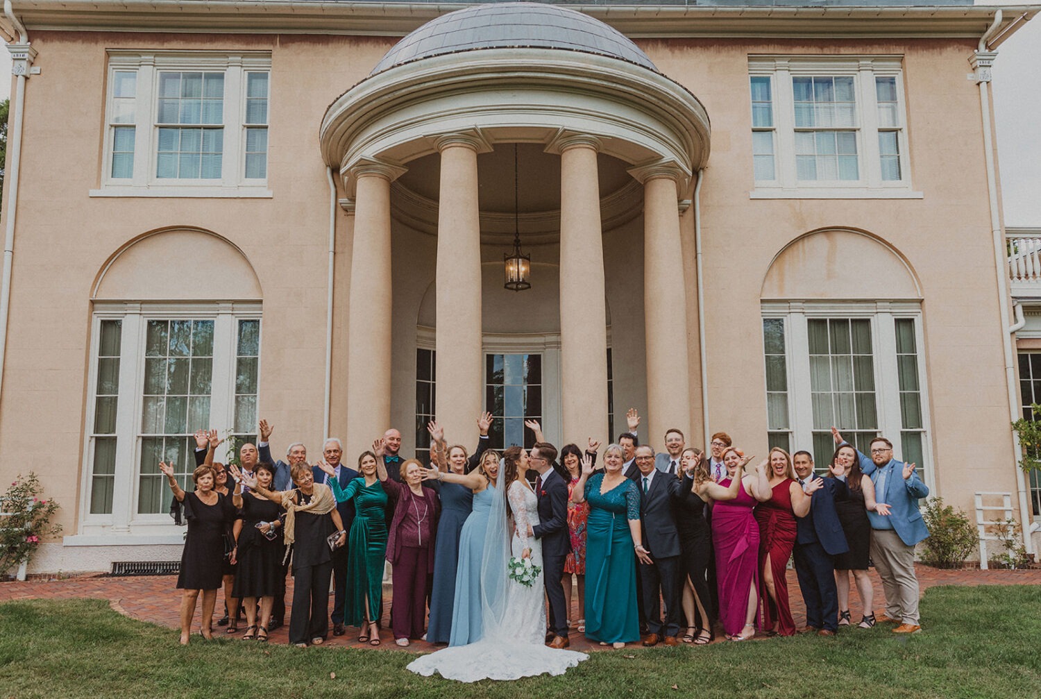 small wedding group photo with the couple and their guests cheering