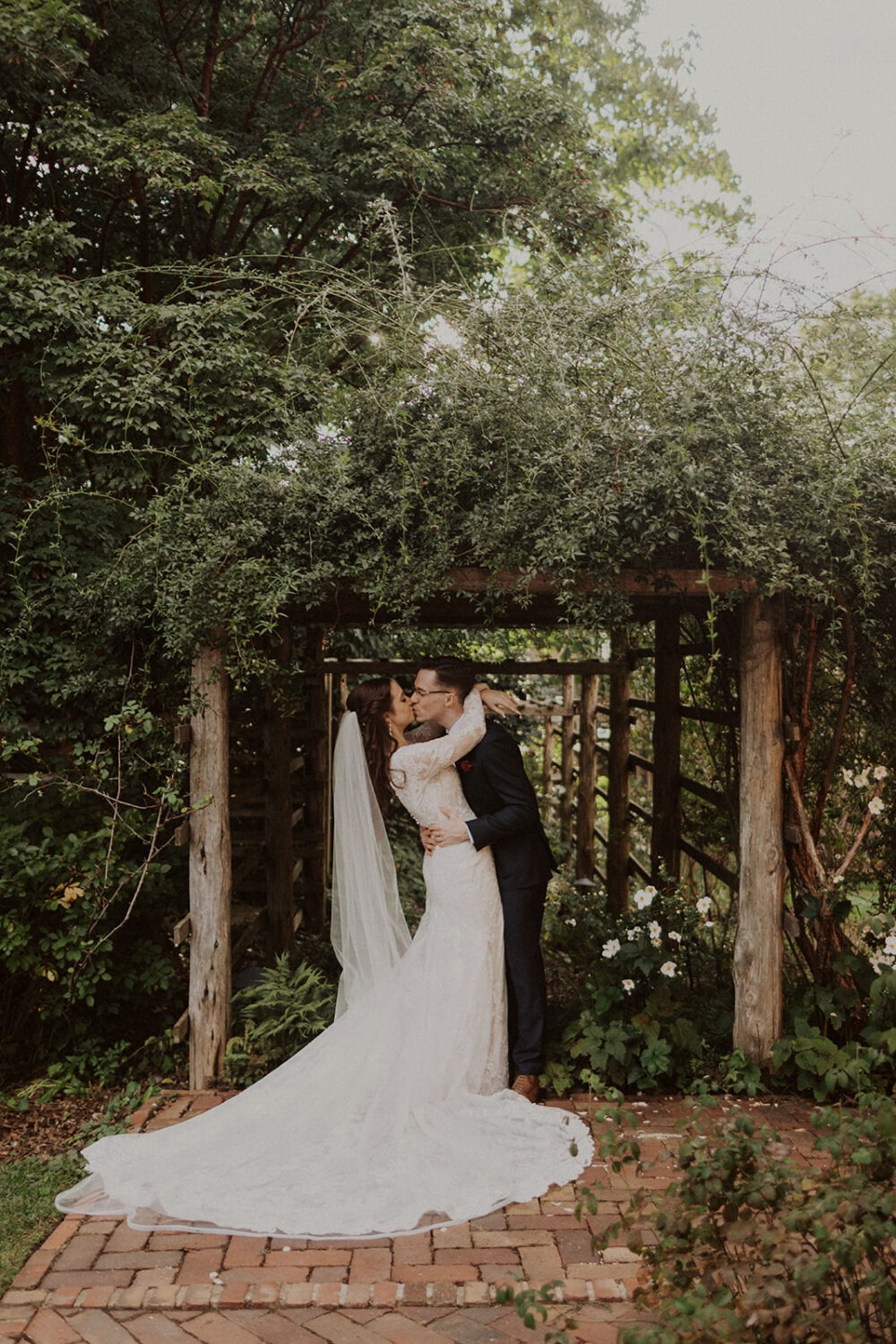 couple kissing under wooden structure