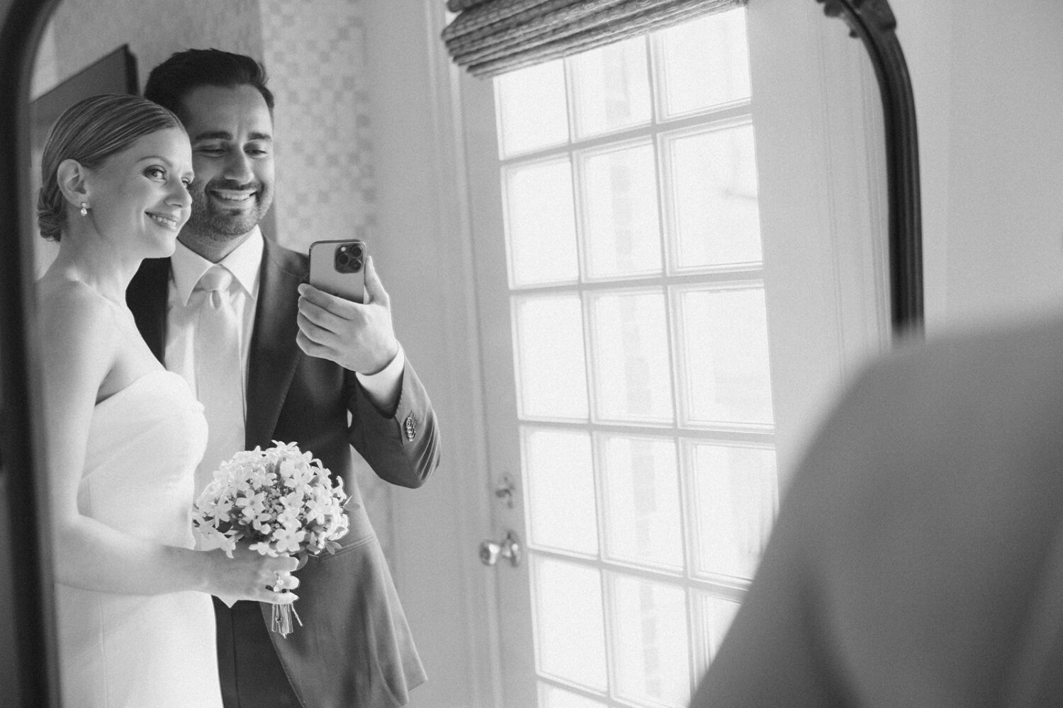 couple takes picture together in front of mirror