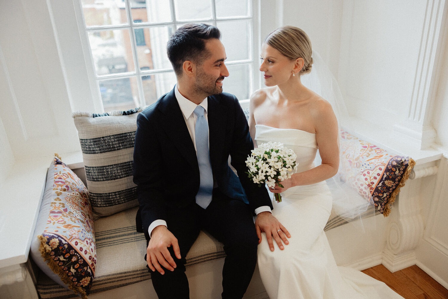 couple sitting on bench in front of window in historic Swann House DC