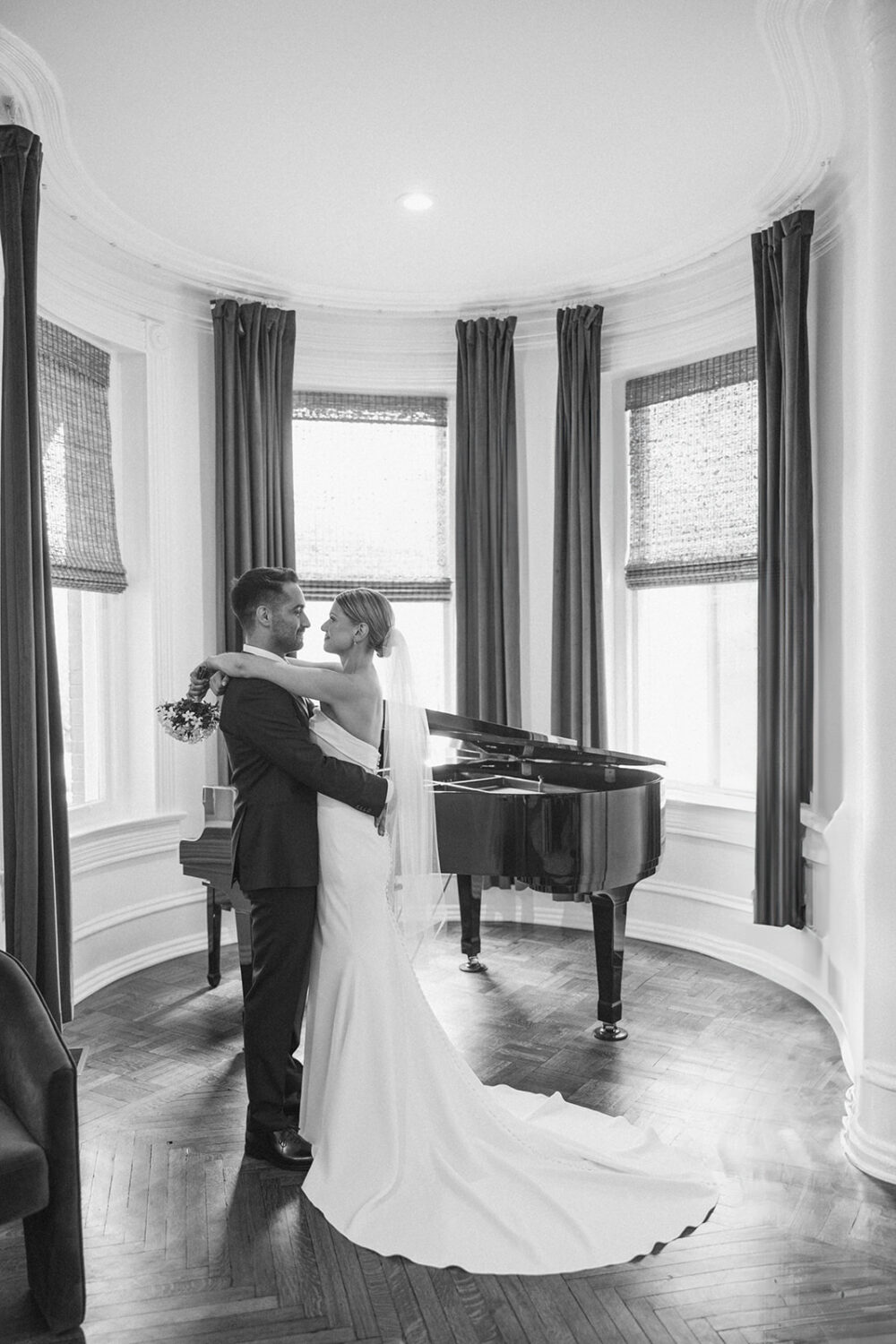 couple embracing in front of piano in the historic Swann House DC