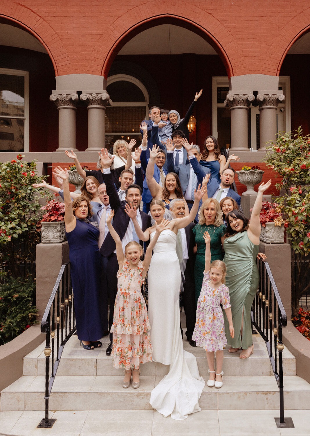 small wedding group photo with the couple and their guests cheering