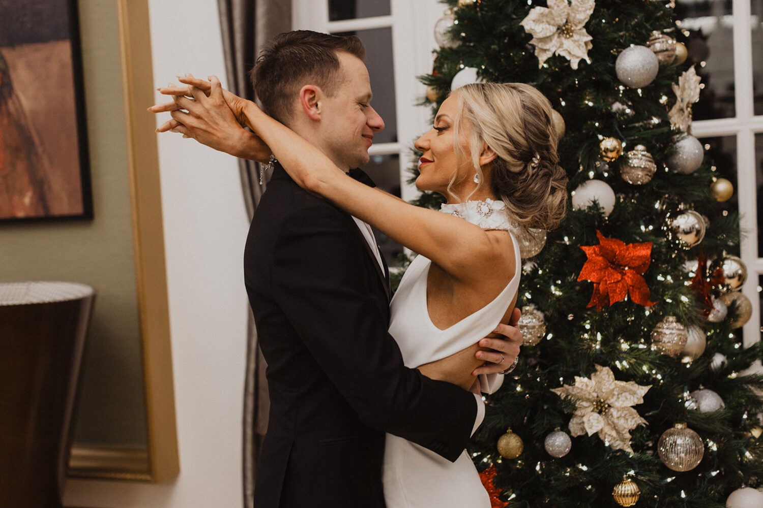 couple embracing in front of Christmas tree