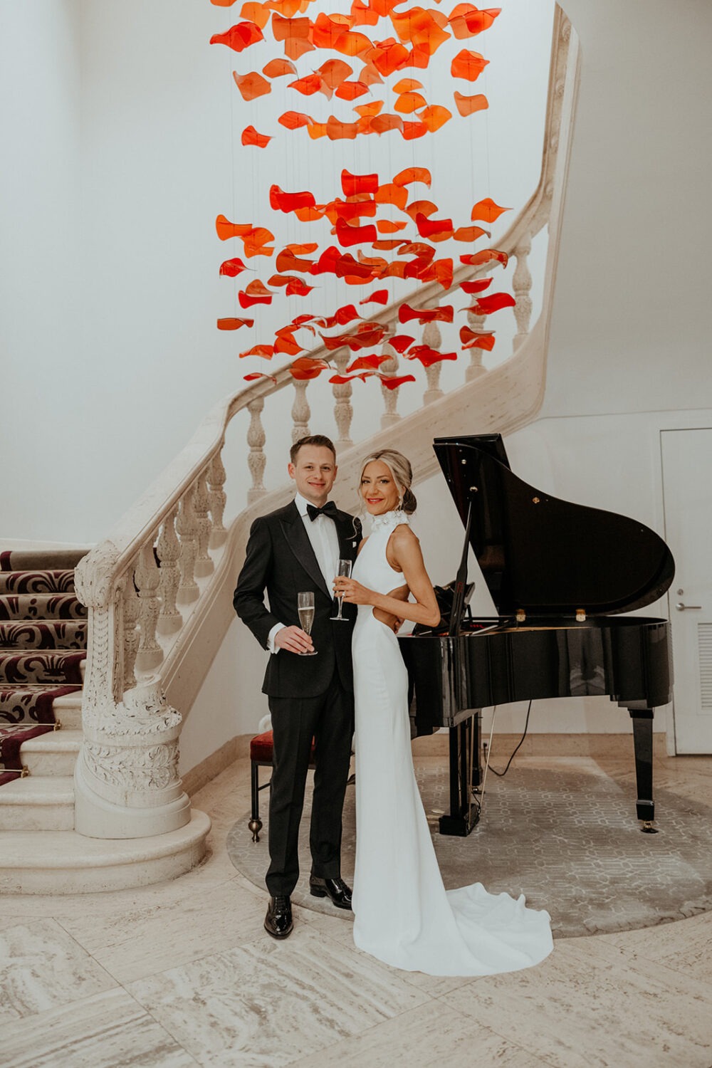 couple posing in front of piano and staircase