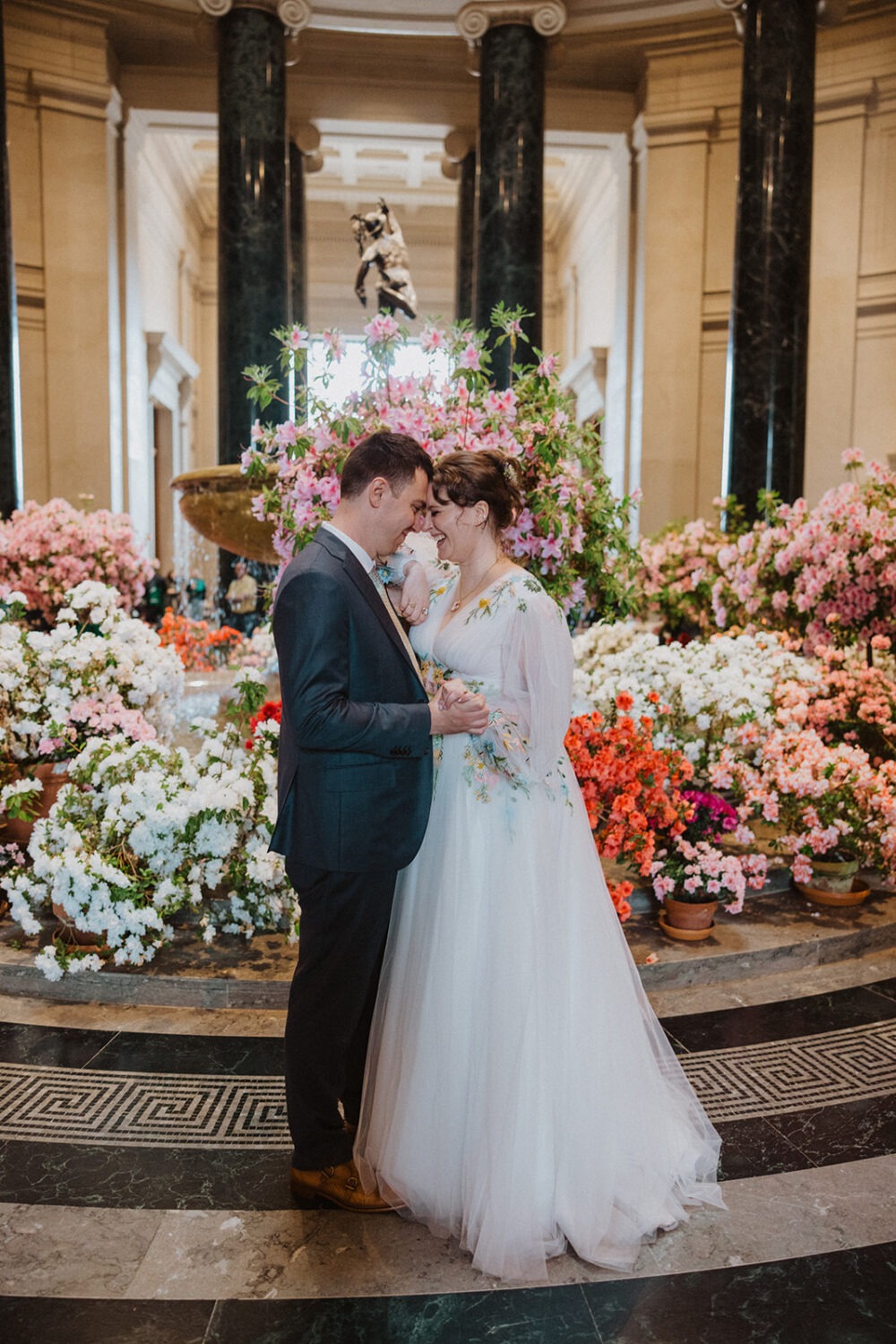 couple posing in front of large flower arrangement in the National Gallery of Art in Washington DC