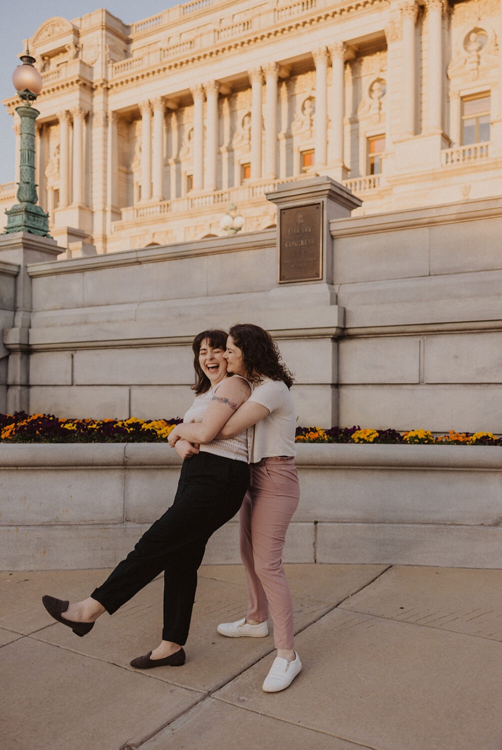 couple twirl each other around during engagement photoshoot