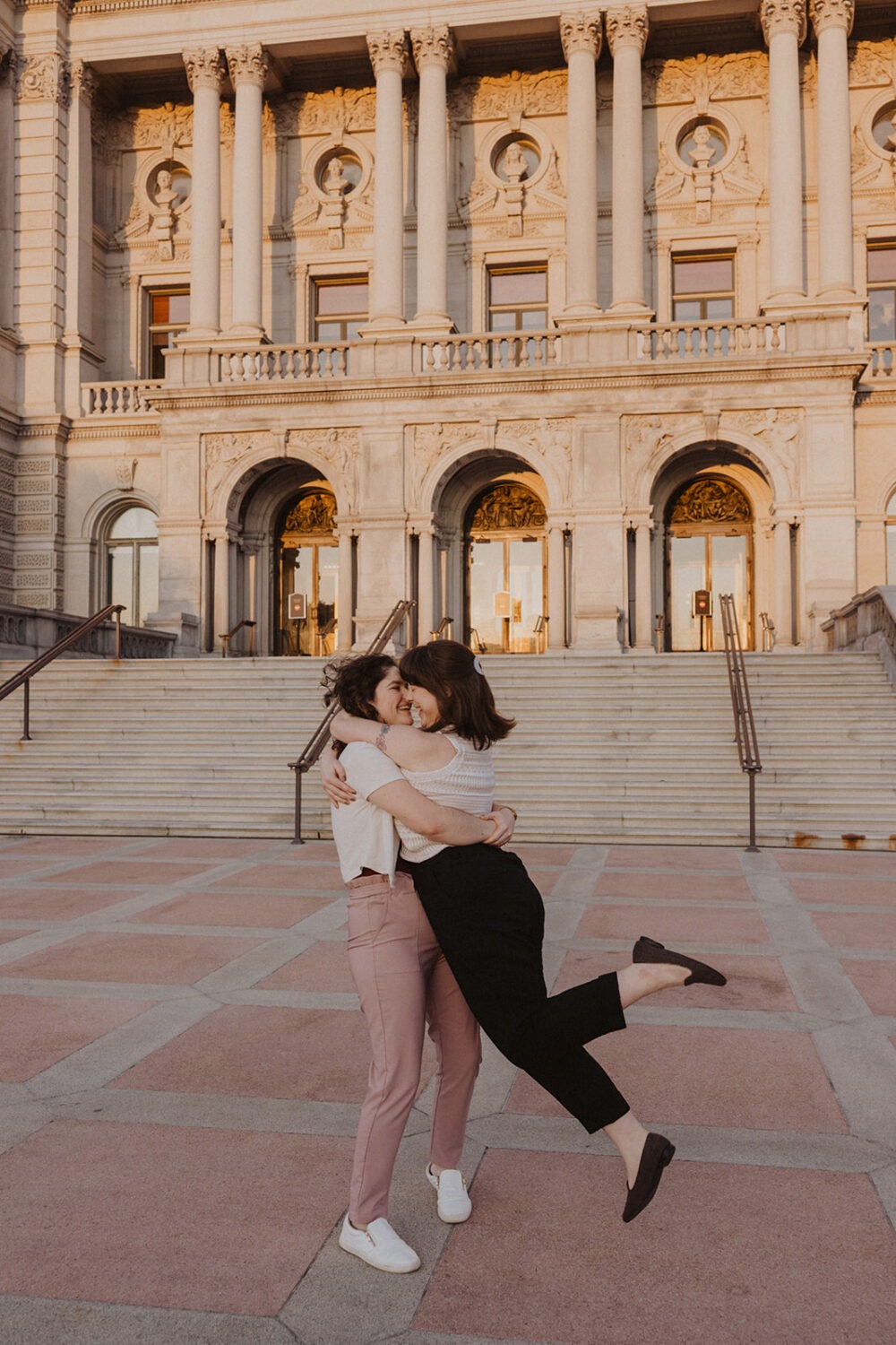 couple spin each other during engagement photoshoot