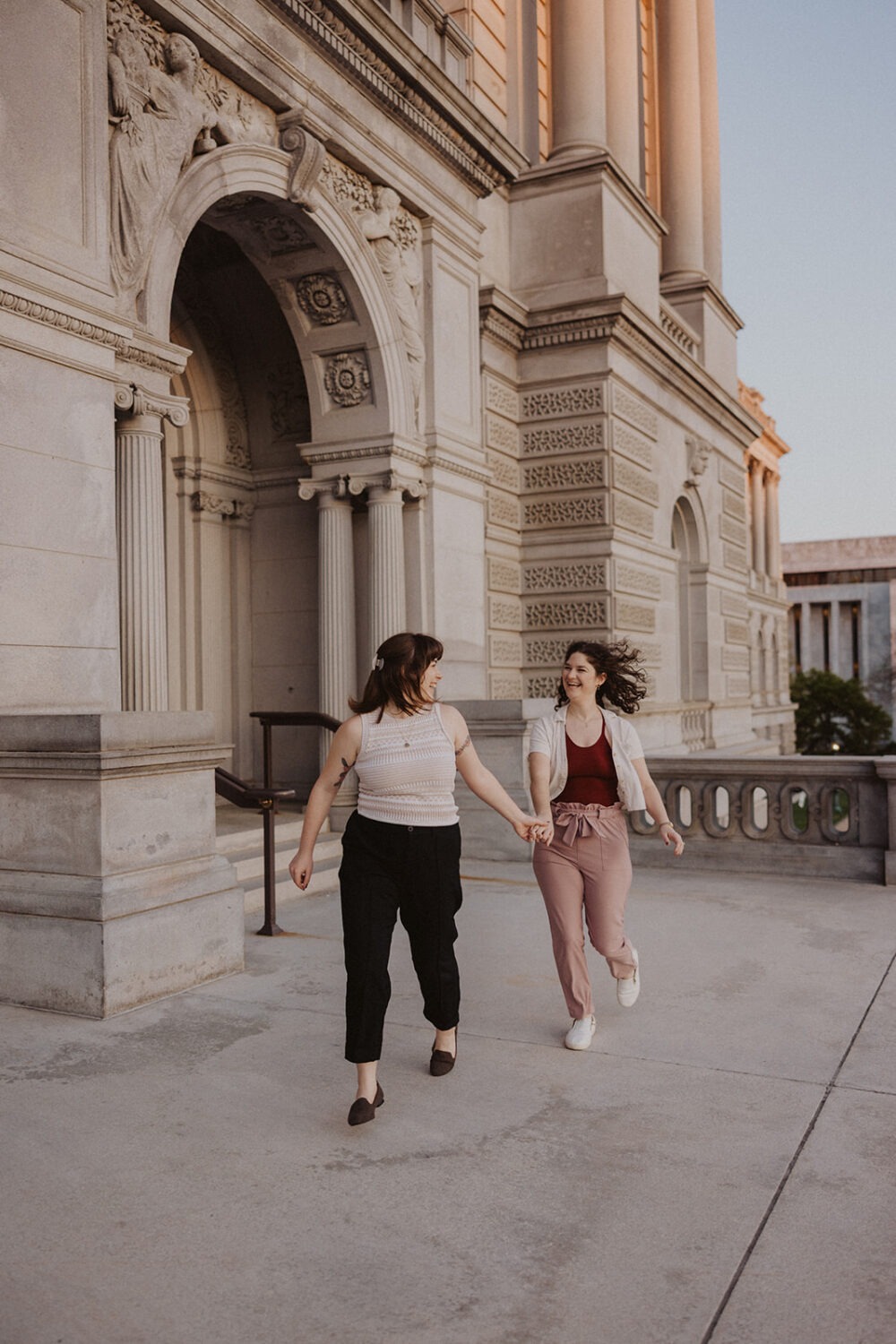 couple running holding hands during engagement photoshoot