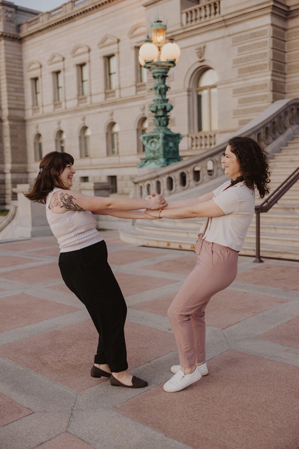 couple spin each other during engagement photoshoot