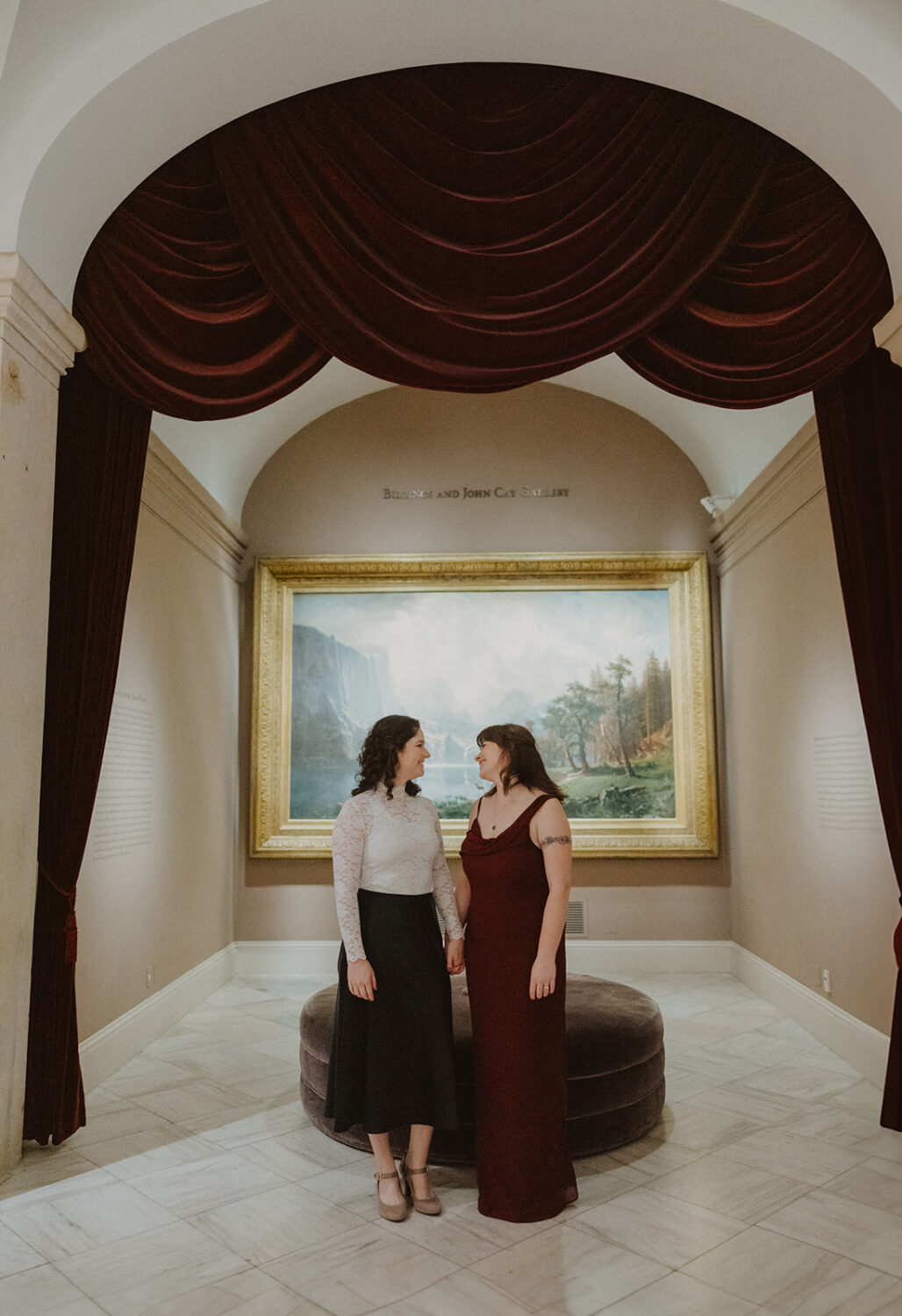 Couple pose in front of large landscape painting in the Portrait Gallery
