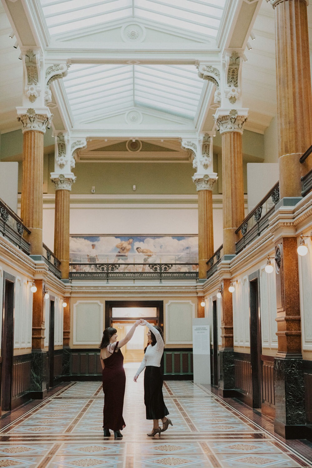 couple twirls around in the grand hallway of the Portrait Gallery
