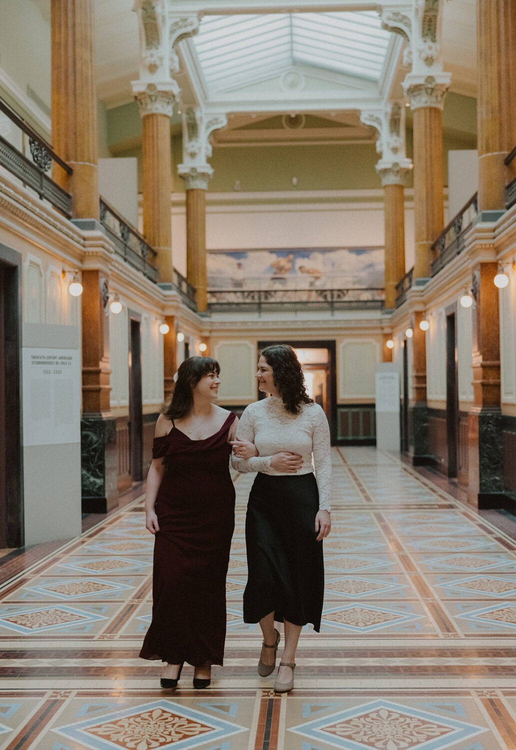 couple walk the grand hall of the Portrait Gallery