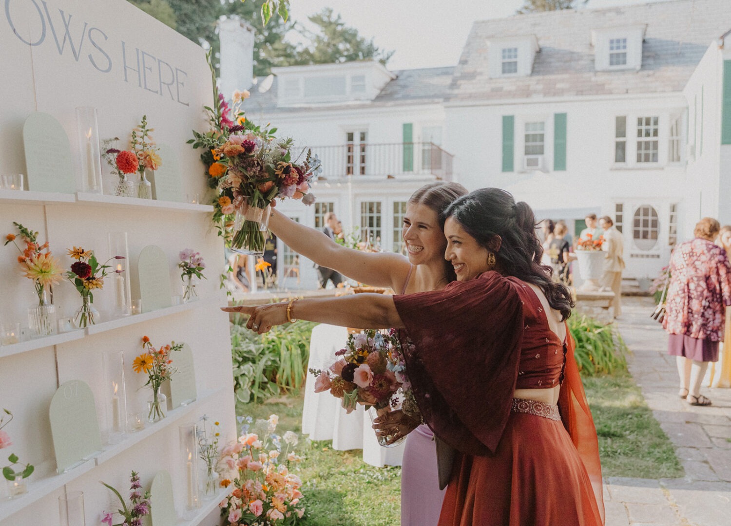 guests searching wall with flowers for table number