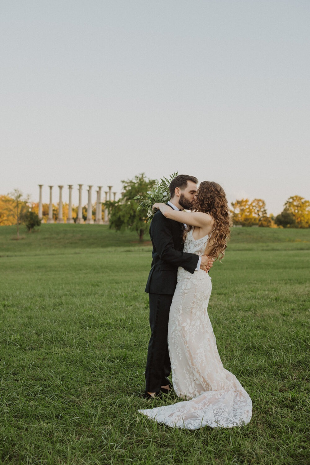couple kiss in Ellipse Meadow at National Arboretum wedding 