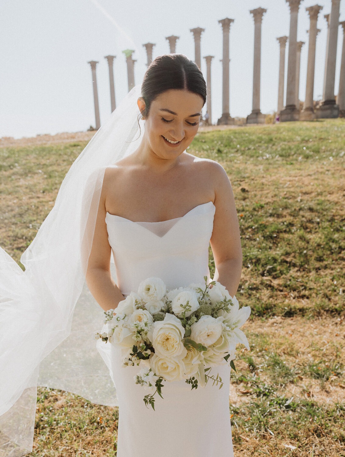 bride poses in front of National Capitol columns