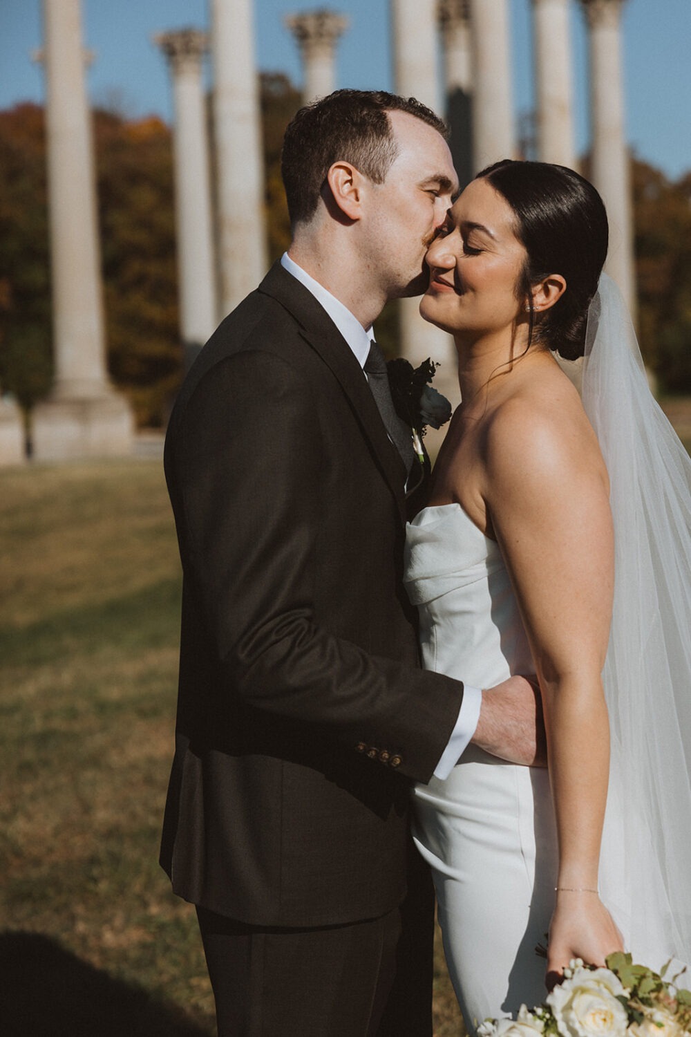 couple kiss in front of National Capitol Columns