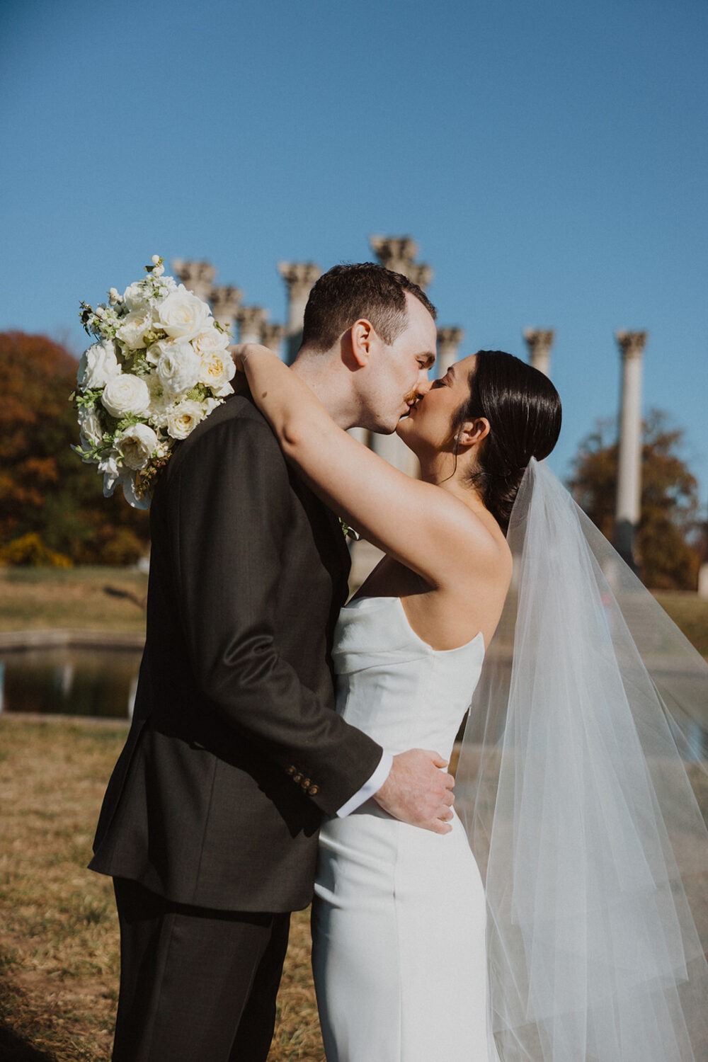 couple kiss in front of National Capitol Columns