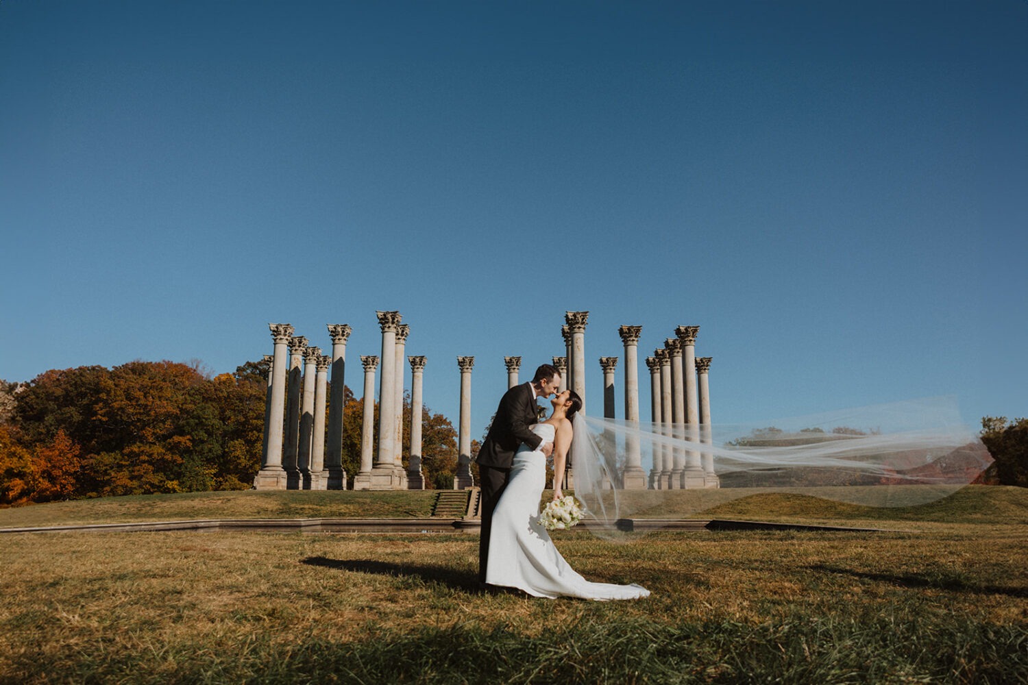 couple kiss in front of National Capitol Columns