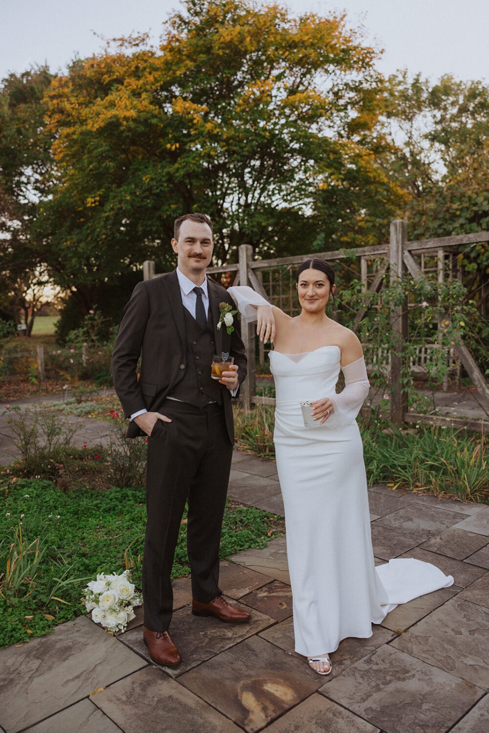 couple pose in Herb Garden with cocktails