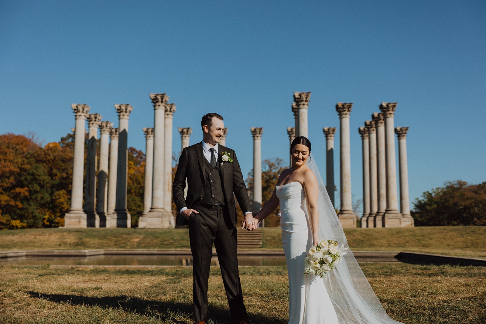 couple poses in front of National Capitol Columns