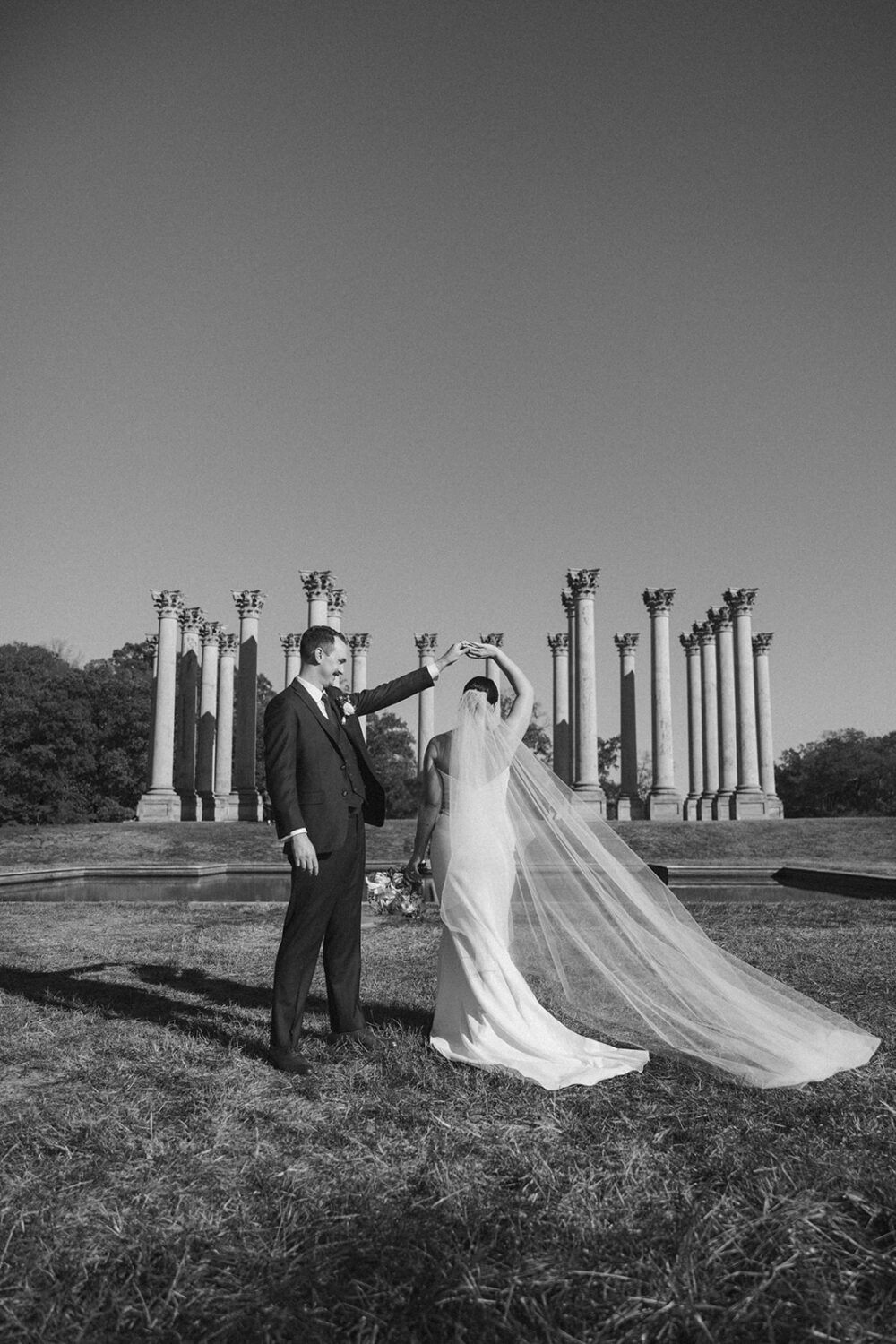 couple pose in front of National Capitol Columns