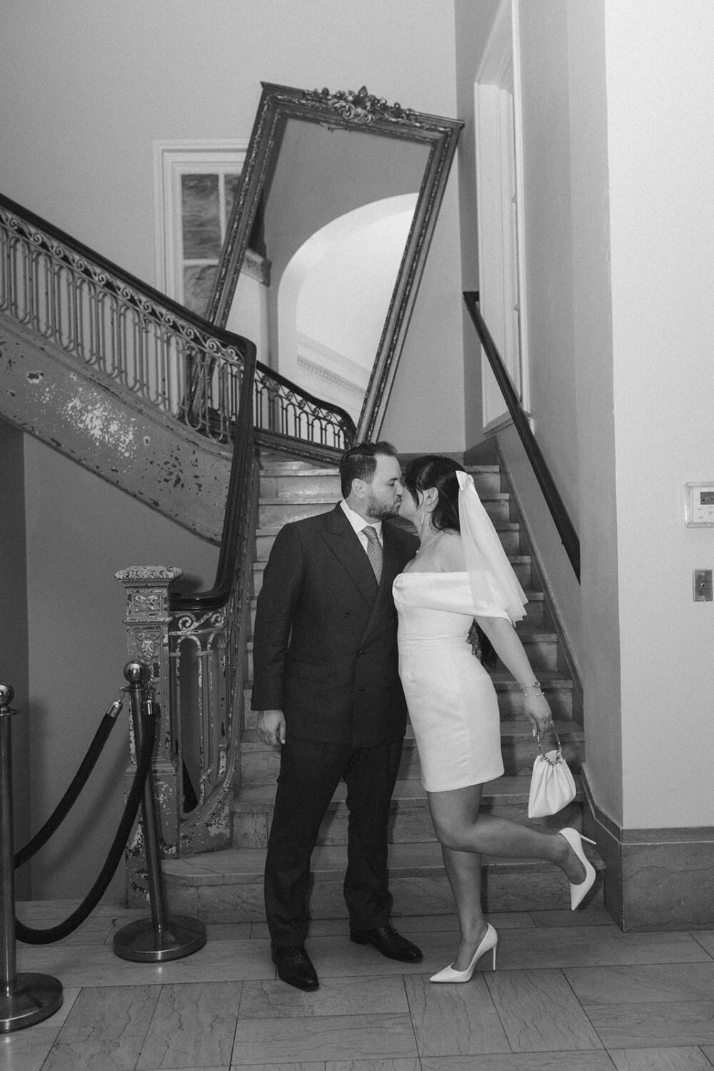 couple kiss in front of hotel steps 