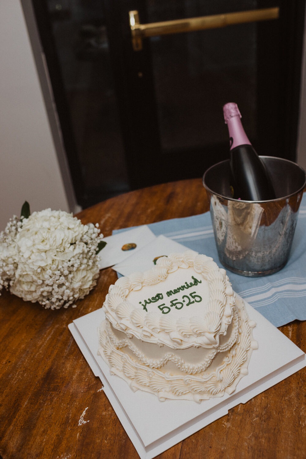 detail shot of wedding cake, champagne, and bouquet