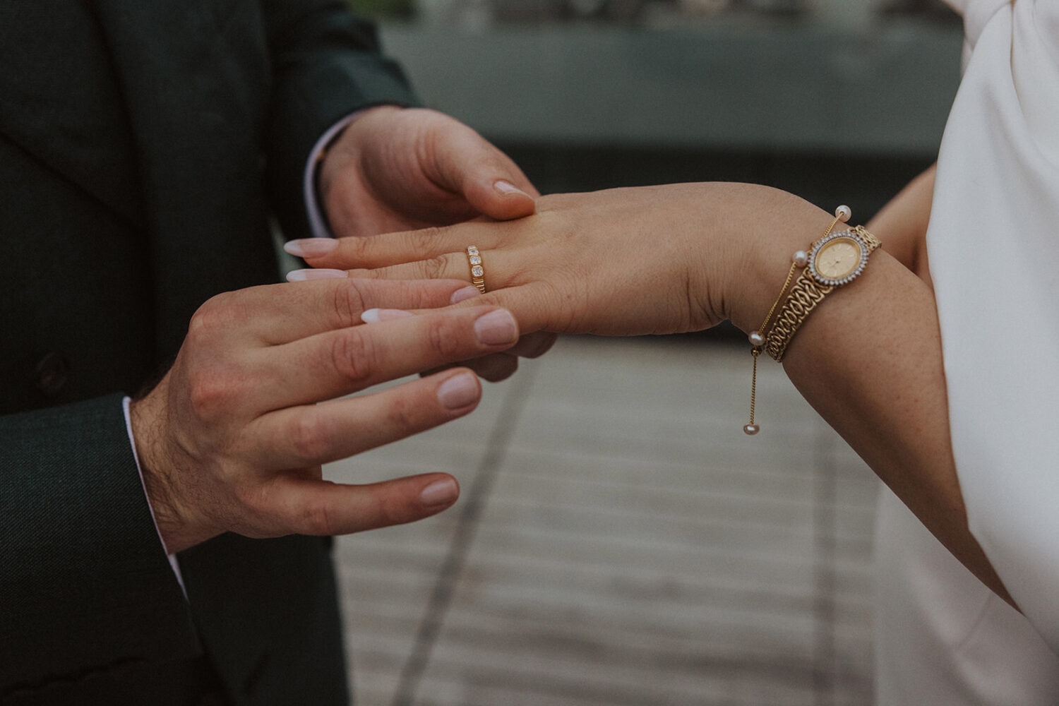 groom putting on wedding ring on bride's finger