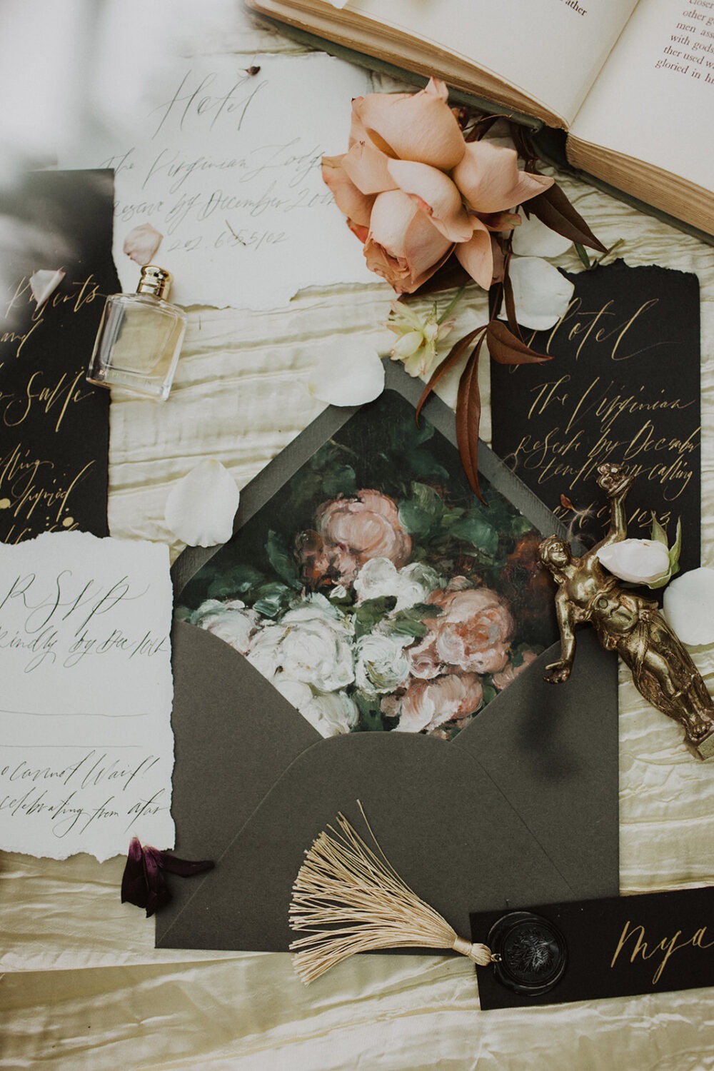 wedding flat lay with full invitation, florals, and perfume