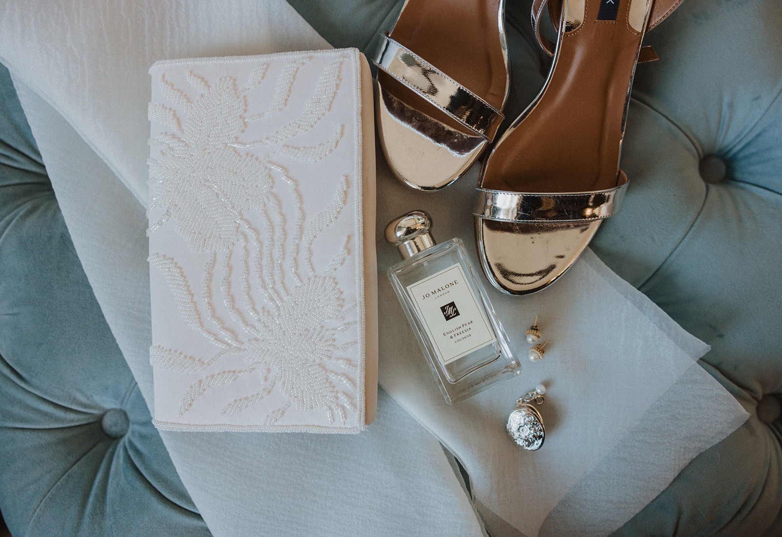 wedding flat lay details of vow book, shoes, and perfume