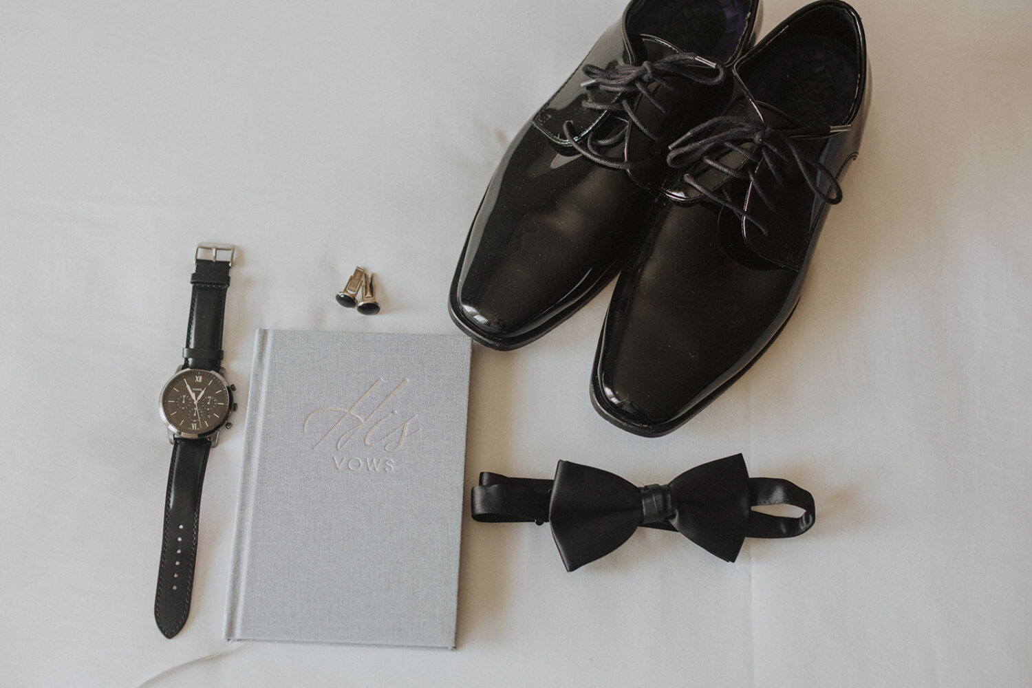 groom details including shoes, watch, cufflinks, bowtie, and vow book