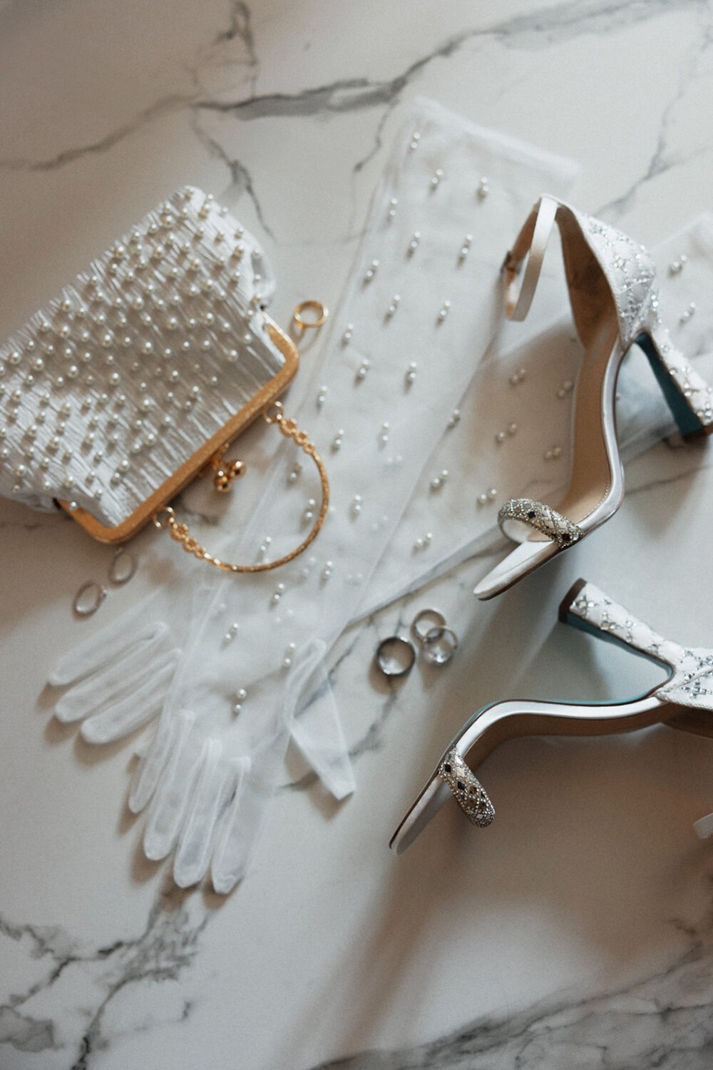 wedding flat lay details including the bride's gloves, shoes, and handbag