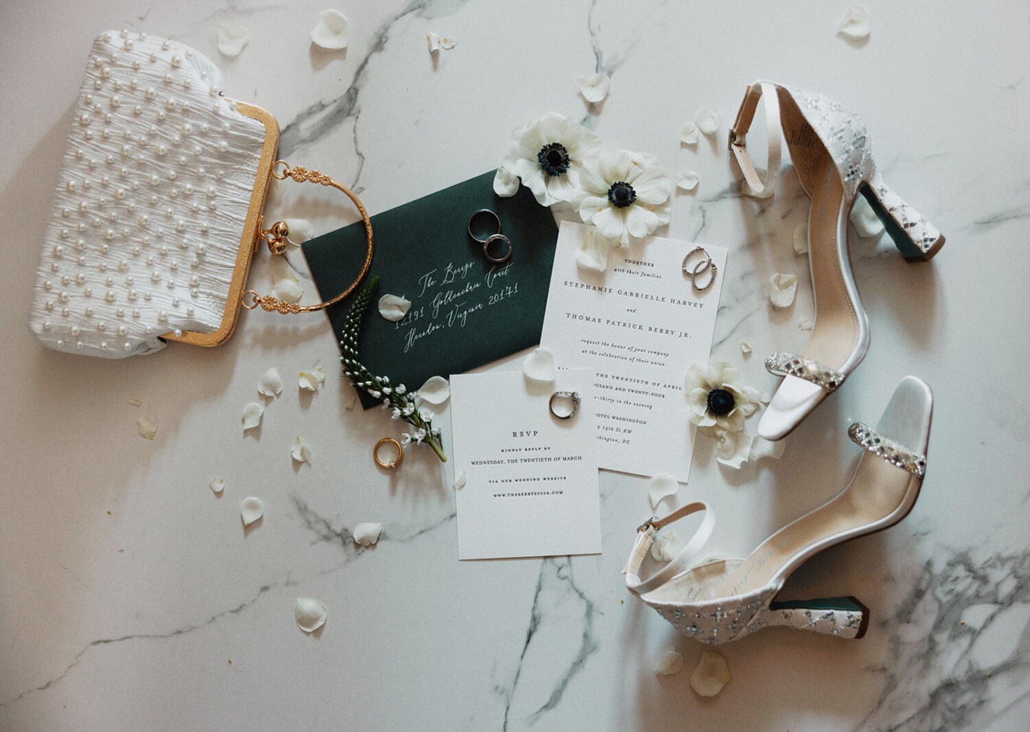 wedding flat lay details with invitation, jewelry, and florals