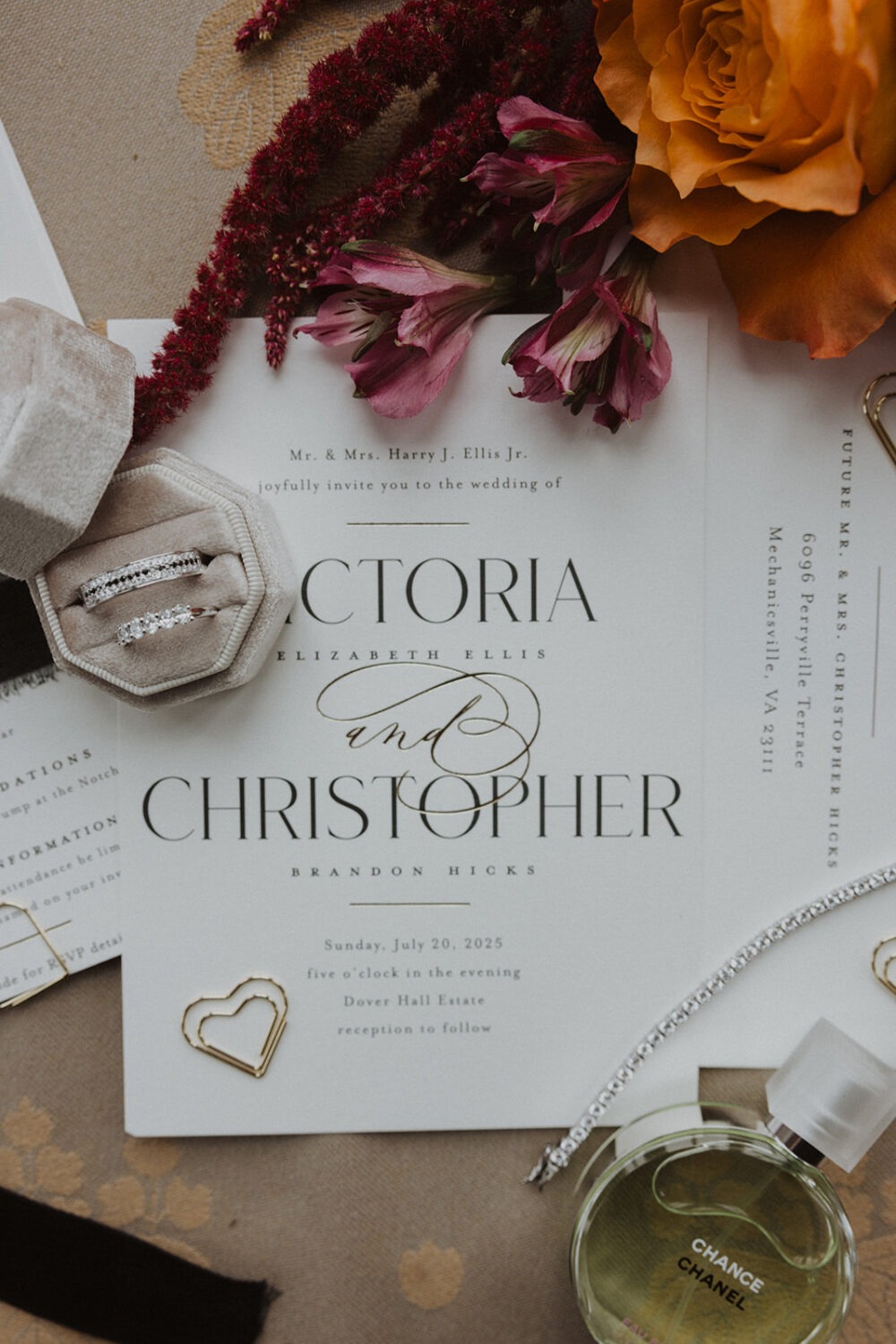 wedding flat lay details with invitation, jewelry, and florals