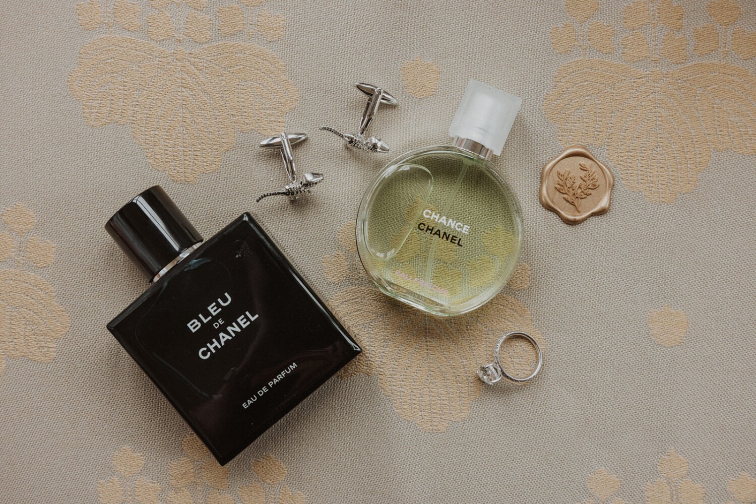 wedding details of perfume, cologne, and jewelry