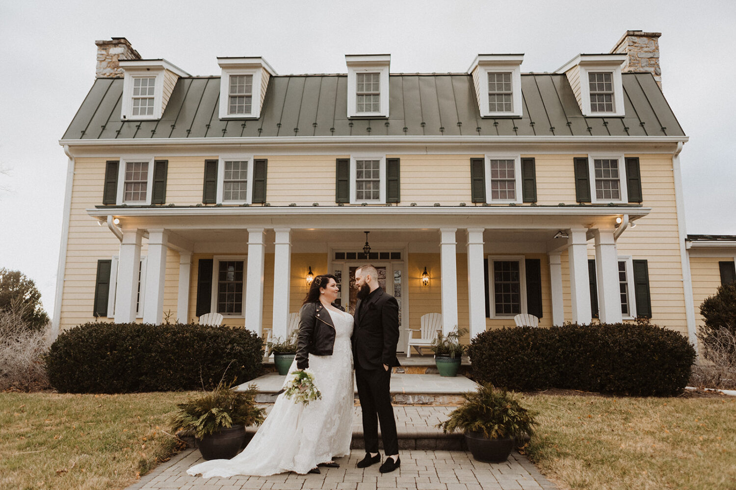 couple pose in front of Hillbrook Inn venue