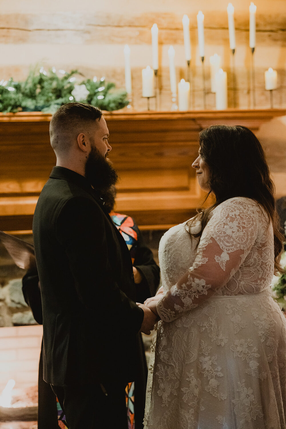 couple hold hands during Christmas wedding ceremony