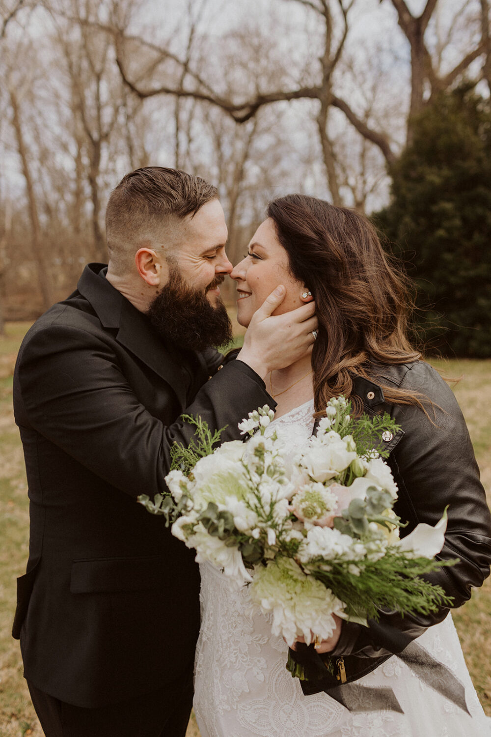 couple embrace for portrait shots showing off wedding bouquet
