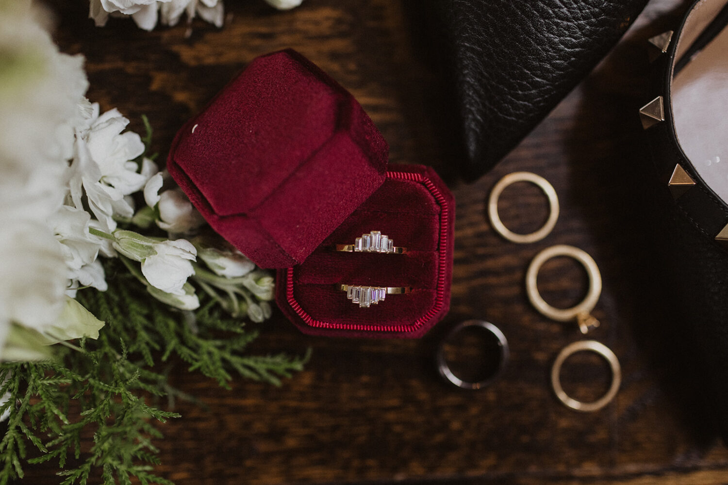 wedding flat lay of rings, shoes, and florals