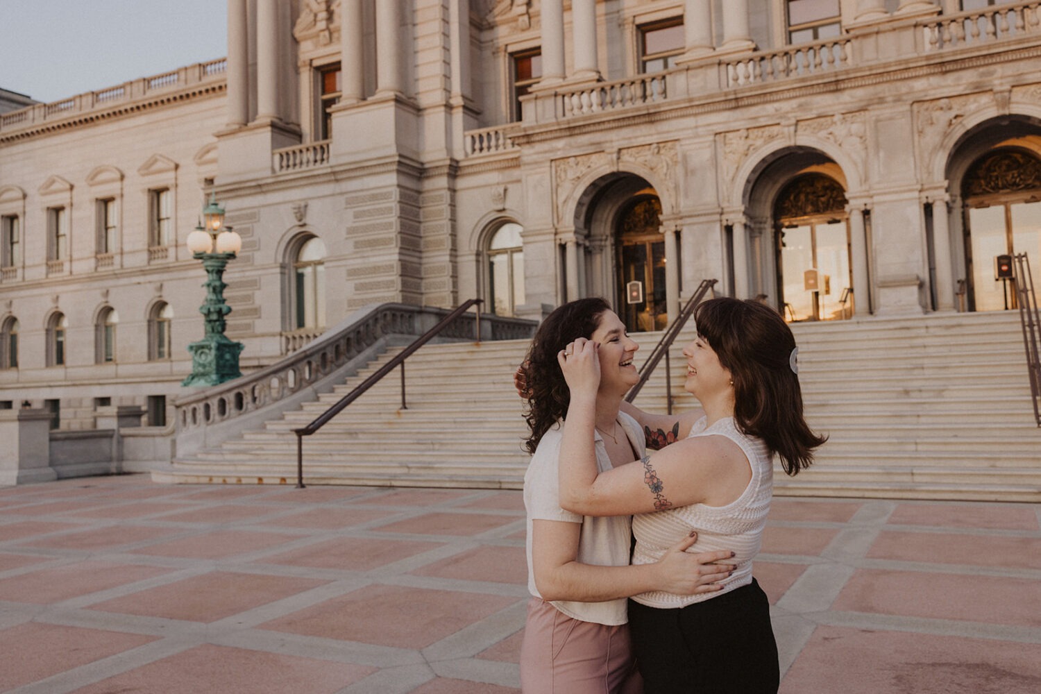couple embrace in front of the Library of Congress