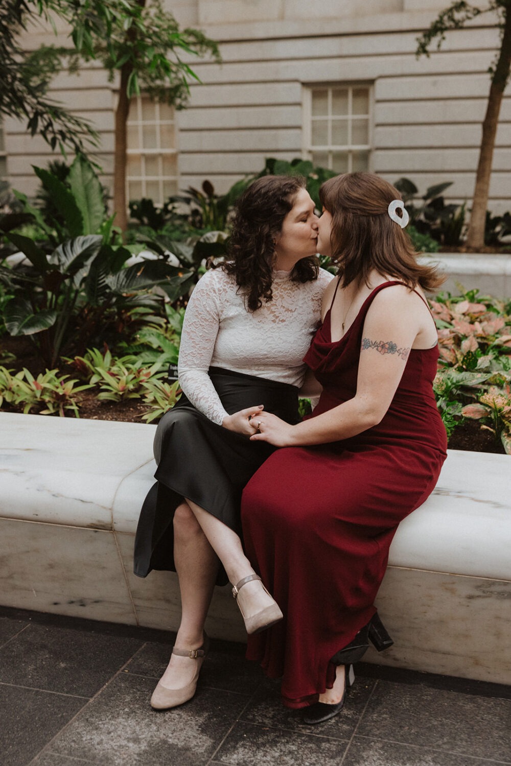 couple sitting on ledge kissing