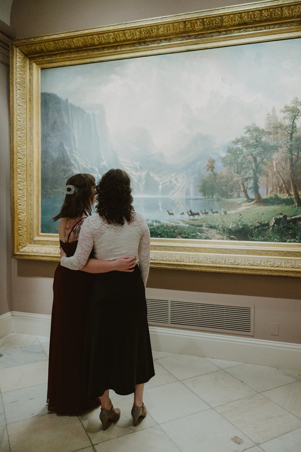 couple embrace while looking at portrait
