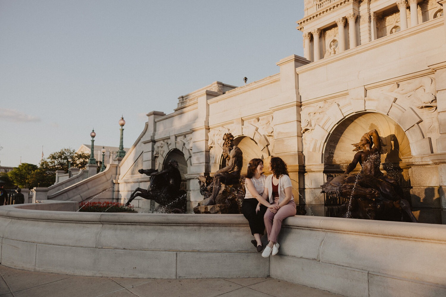 couple sit on ledge in front of the Library of Congress