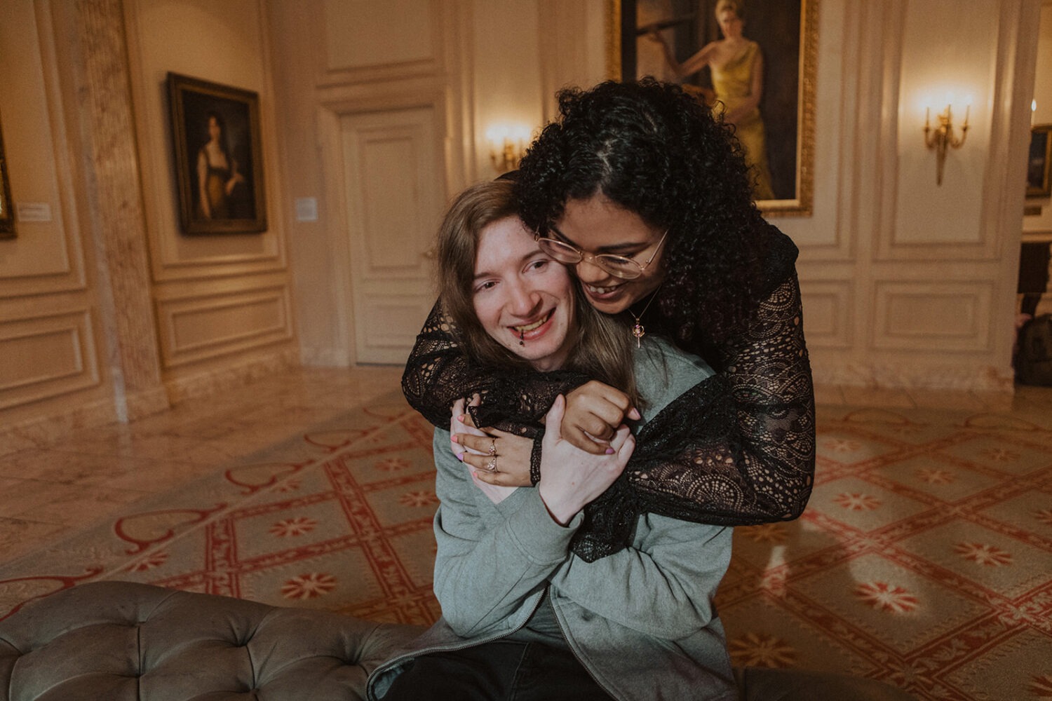 couple embrace among a gallery of portraits
